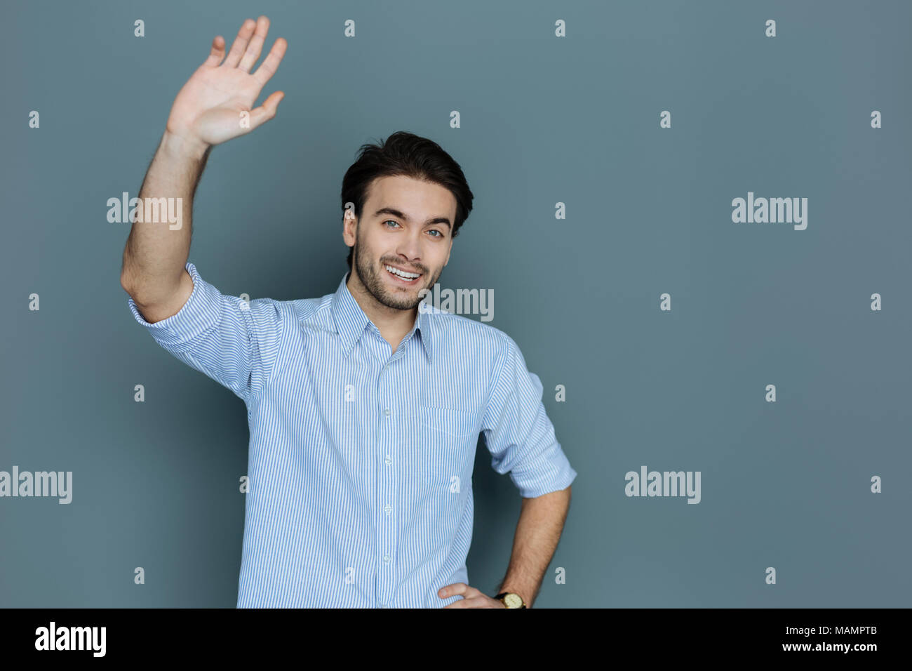 Positive freundliche Mann hielt seine Hand Stockfoto