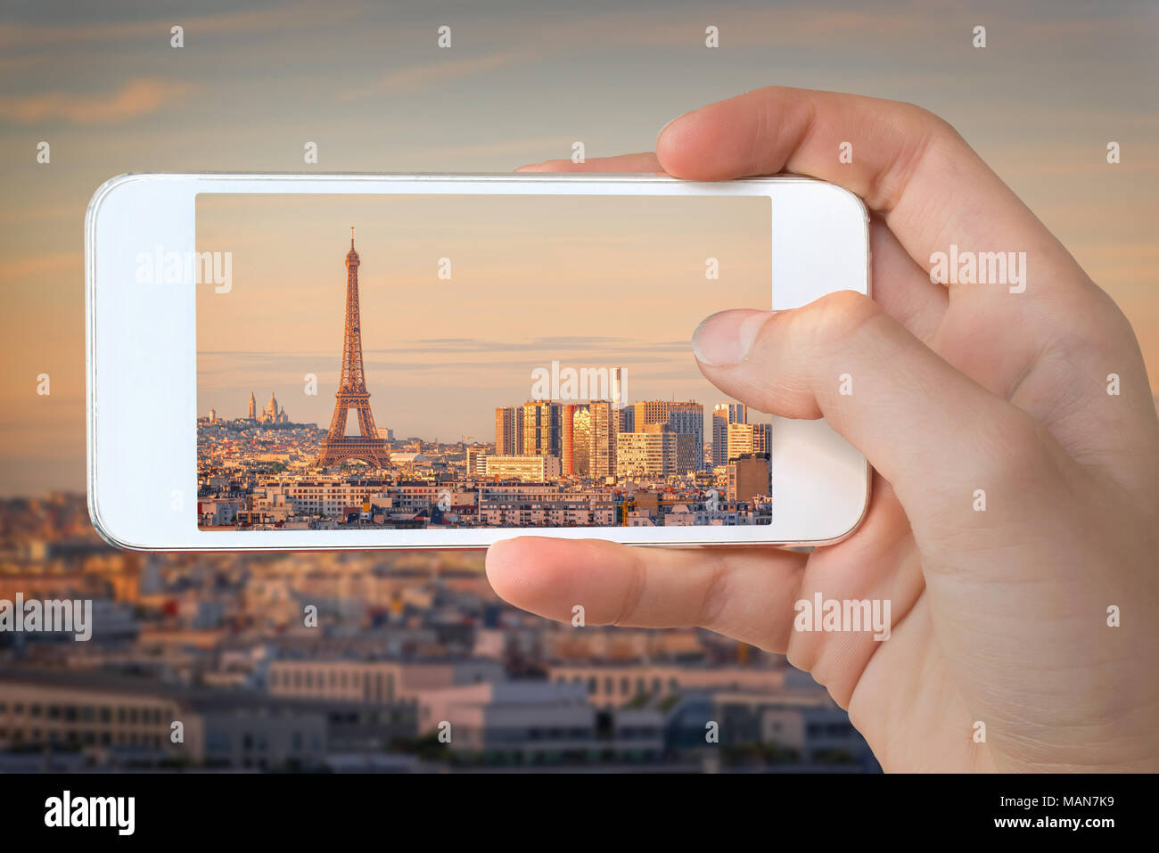 Nahaufnahme einer Hand mit Smartphone ein Bild von Paris mit dem Eiffelturm bei Sonnenuntergang, Frankreich Stockfoto