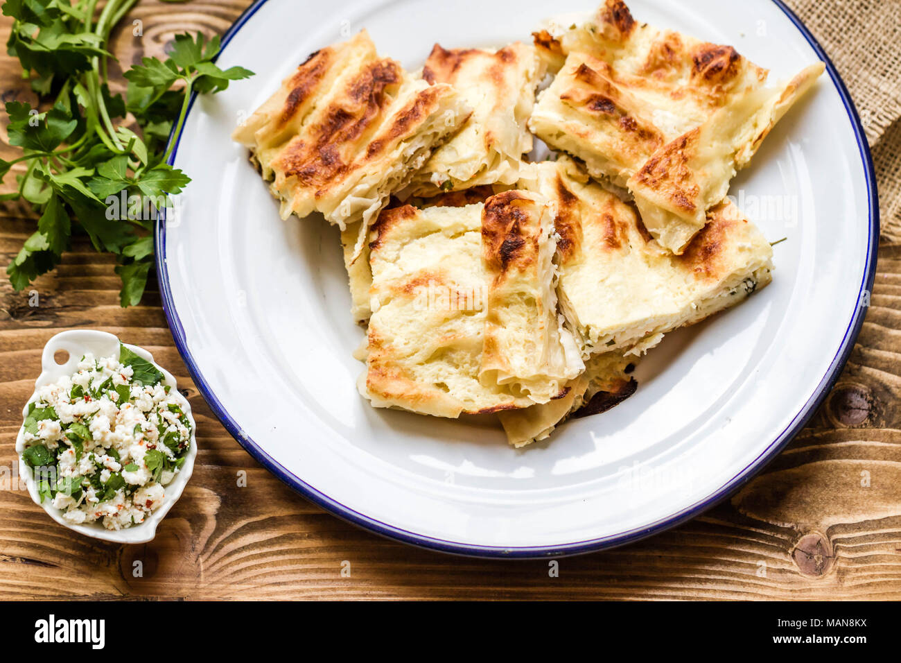 Hausgemachten köstlichen türkischen Stil Käse torte in Emaille Teller auf Holz- Hintergrund Stockfoto