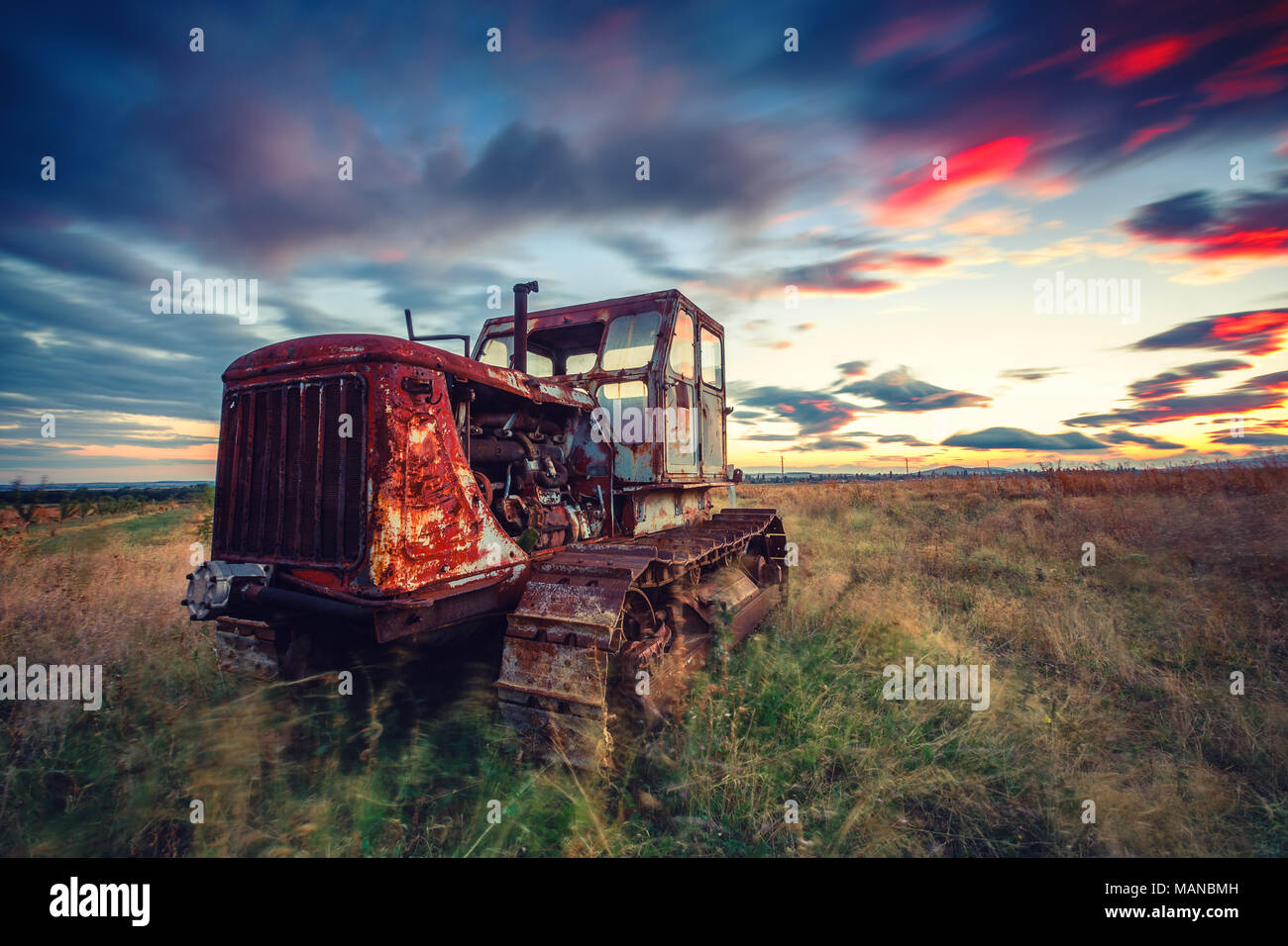 Schönen Sonnenuntergang über Feld und alten verrosteten Traktor. HDR Stockfoto