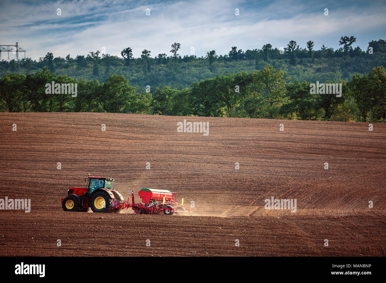 Bauer im Traktor vorbereiten Ackerland mit Saatgut für das nächste Jahr Stockfoto