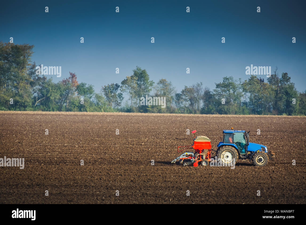 Bauer mit Traktor säen ernten in das Feld Stockfoto