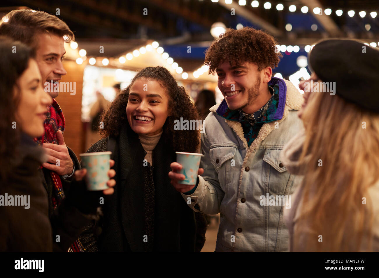 Gruppe von Freunden trinken Glühwein am Weihnachtsmarkt Stockfoto