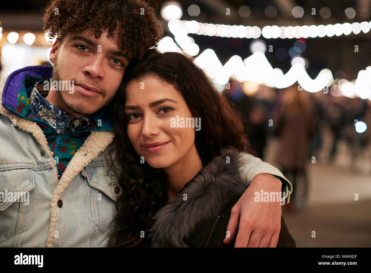 Porträt der jungen Freunde genießen Weihnachtsmarkt bei Nacht Stockfoto