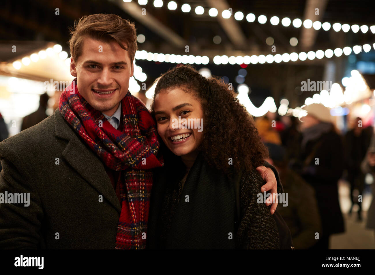 Portrait von Paar beim Weihnachtsmarkt bei Nacht Stockfoto