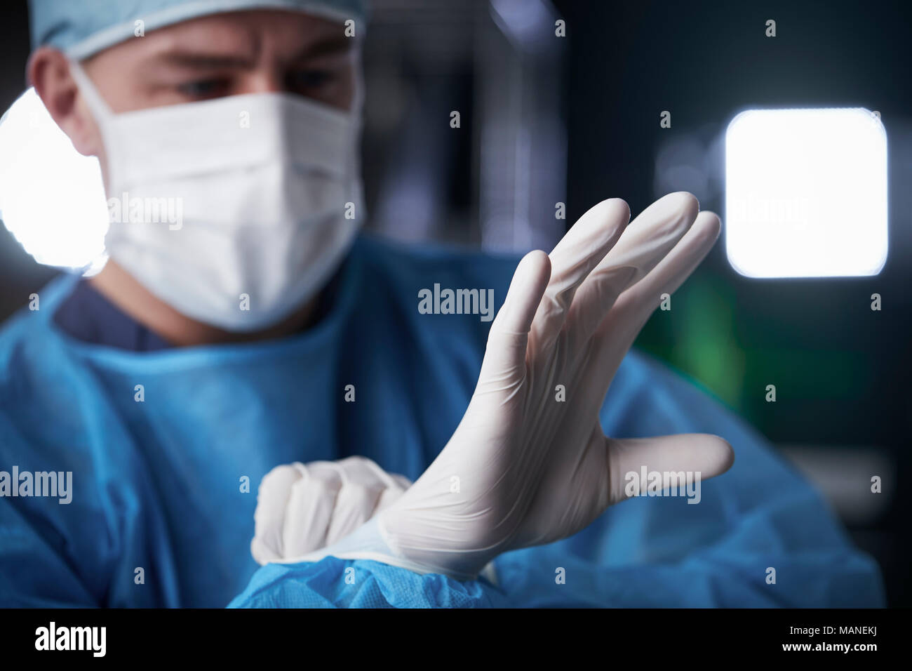 Männliche Chirurgen setzen auf Latex Handschuhe in Vorbereitung Stockfoto