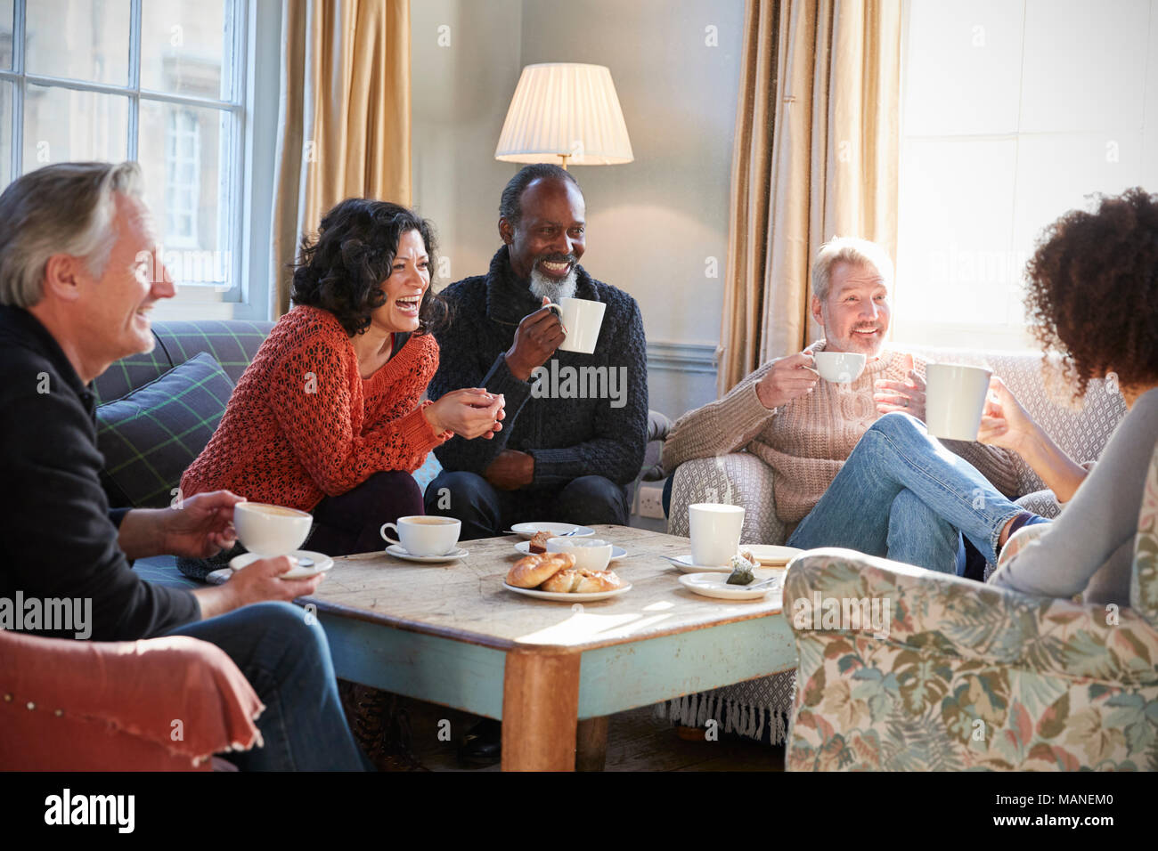 Gruppe der mittleren Alter Freunde zu treffen um den Tisch im Café Stockfoto