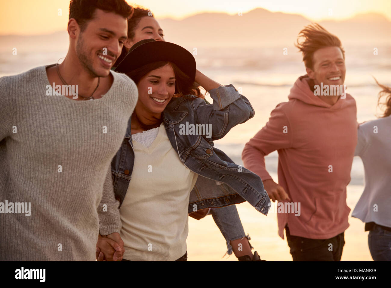 Gruppe von Freunden Spaß entlang Winter Beach Zusammen läuft Stockfoto