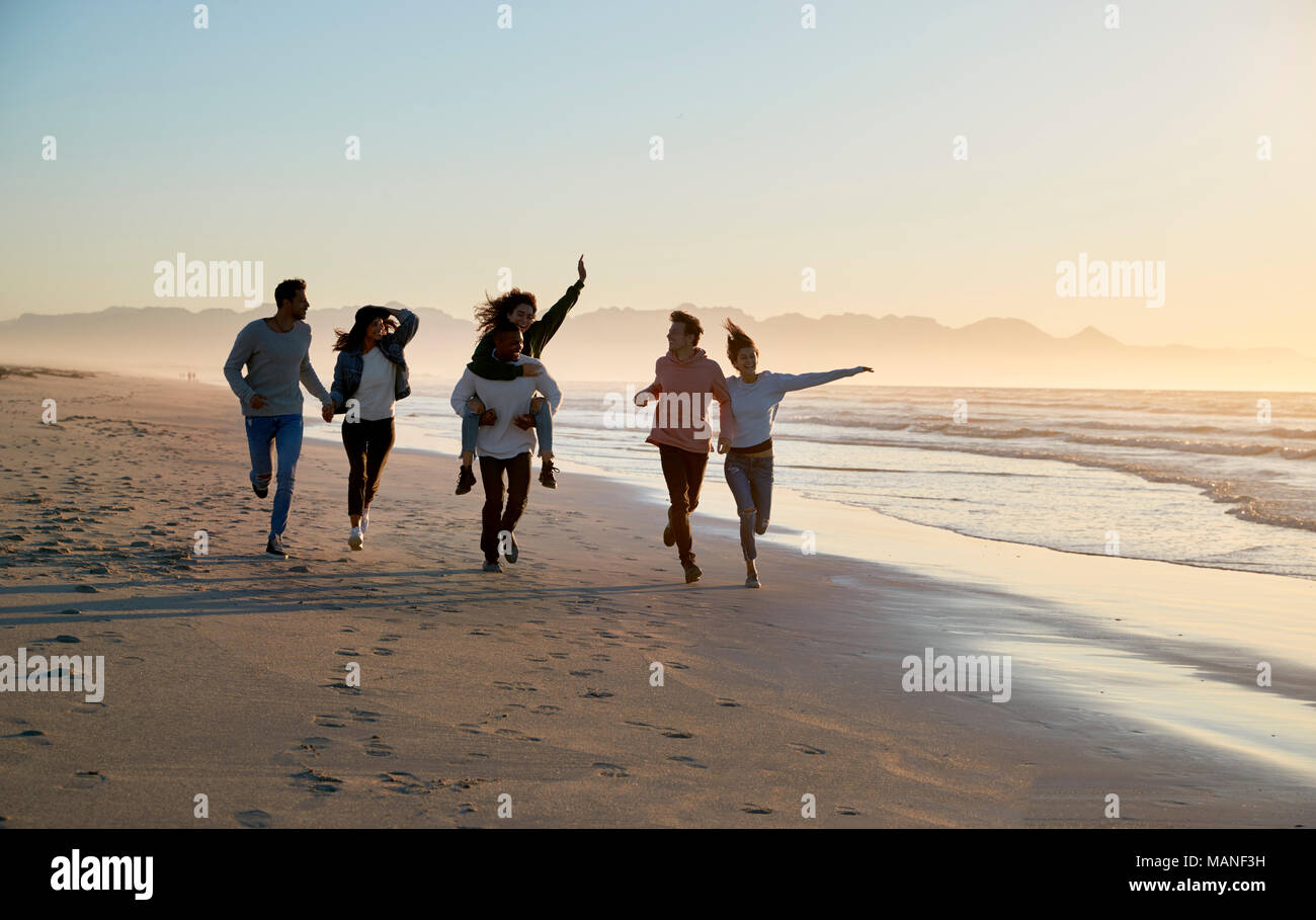 Gruppe von Freunden Spaß entlang Winter Beach Zusammen läuft Stockfoto