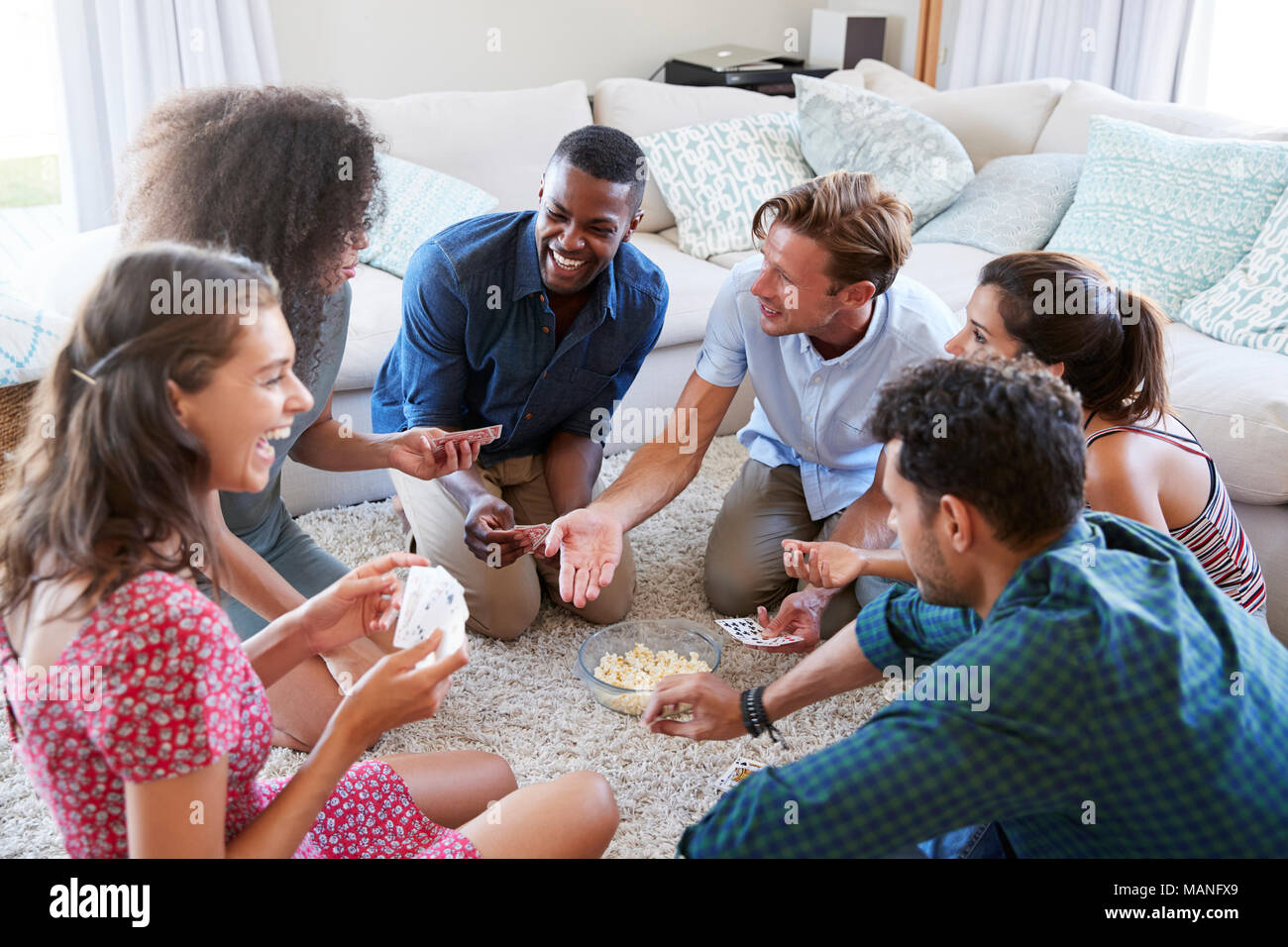 Eine Gruppe von Freunden zu Hause Karten zusammen Stockfoto