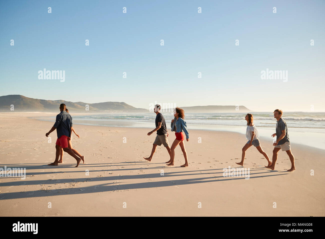 Eine Gruppe von Freunden auf Urlaub gehen entlang Beach zusammen Stockfoto