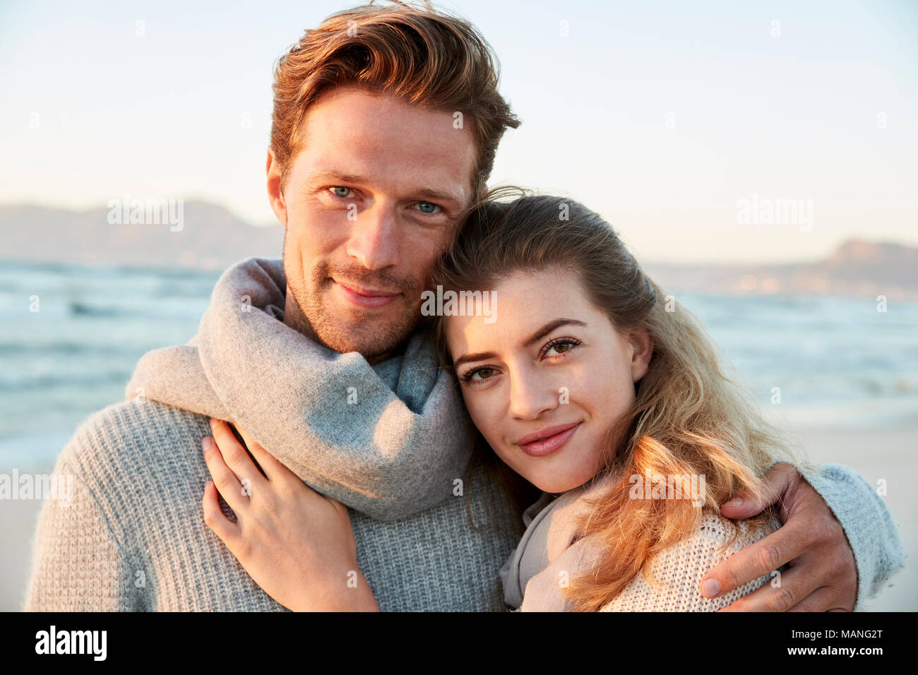 Portrait von liebenden Paar entlang Winter Beach zusammen Wandern Stockfoto