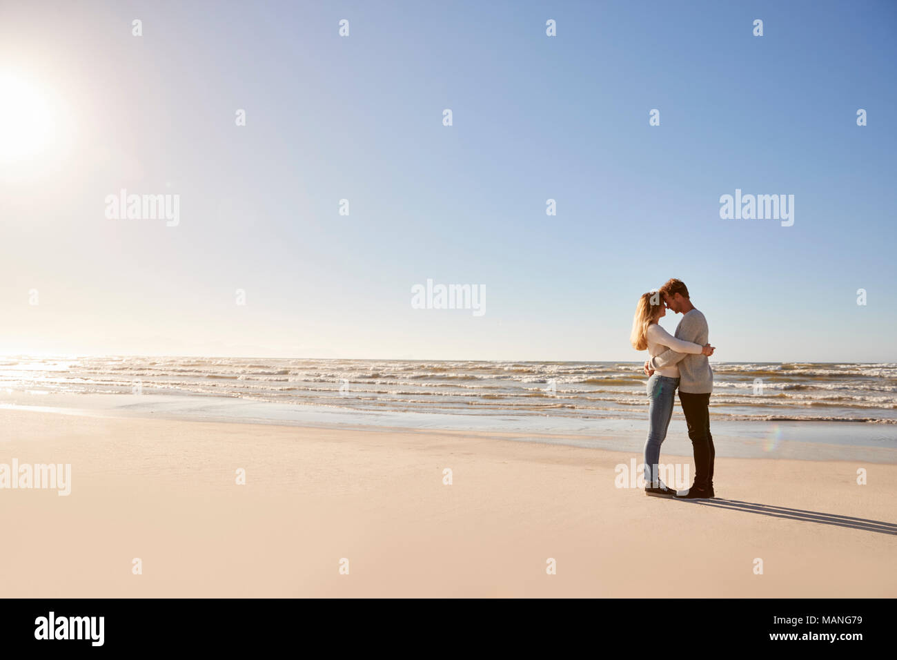 Romantisches Paar, das im Winter Strand Stockfoto