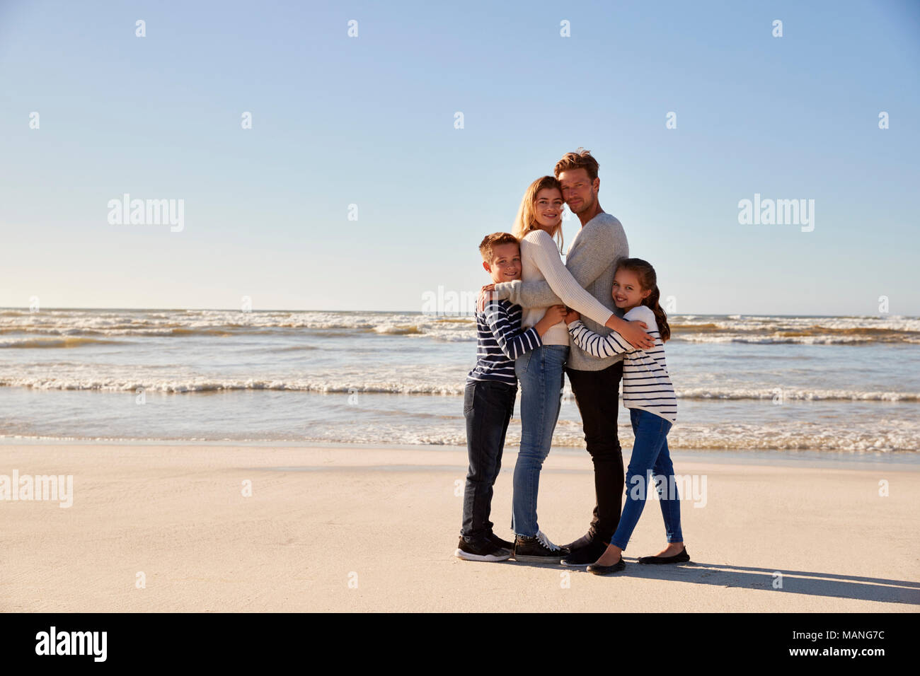 Porträt der Familie, die auf der Winter Beach Stockfoto
