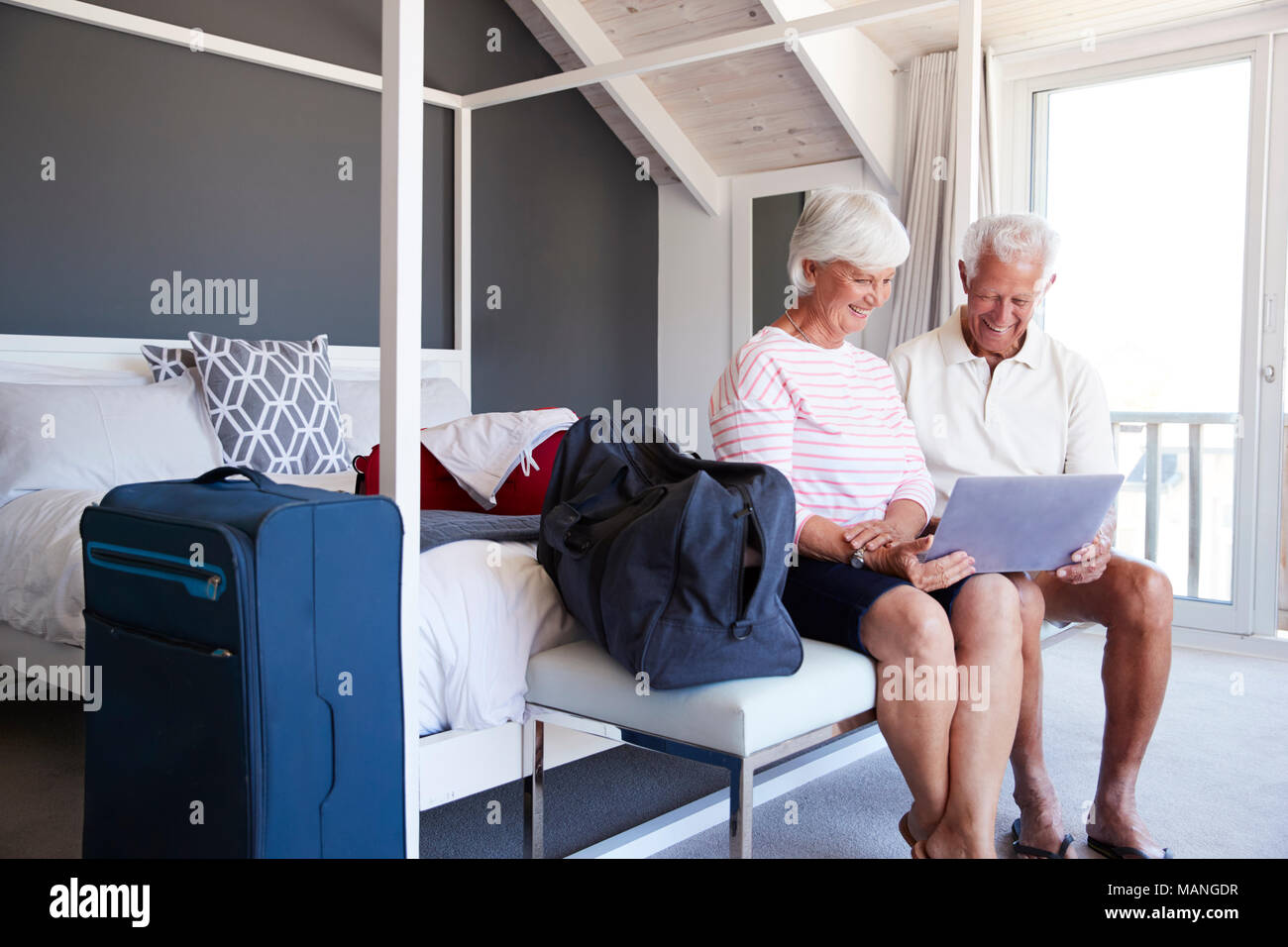 Älteres Ehepaar am Laptop schauen, wie Sie in der Wohnung überprüfen Stockfoto