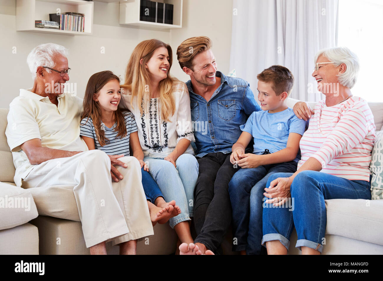 Multi-Generation Familie entspannt auf einem Sofa zu Hause zusammen Stockfoto