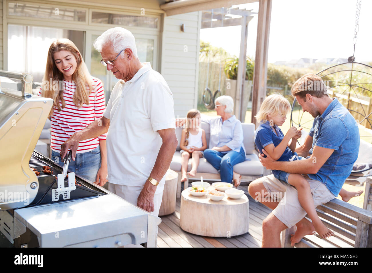 Multi-Generation Familie genießen Kochen Grill zu Hause Stockfoto