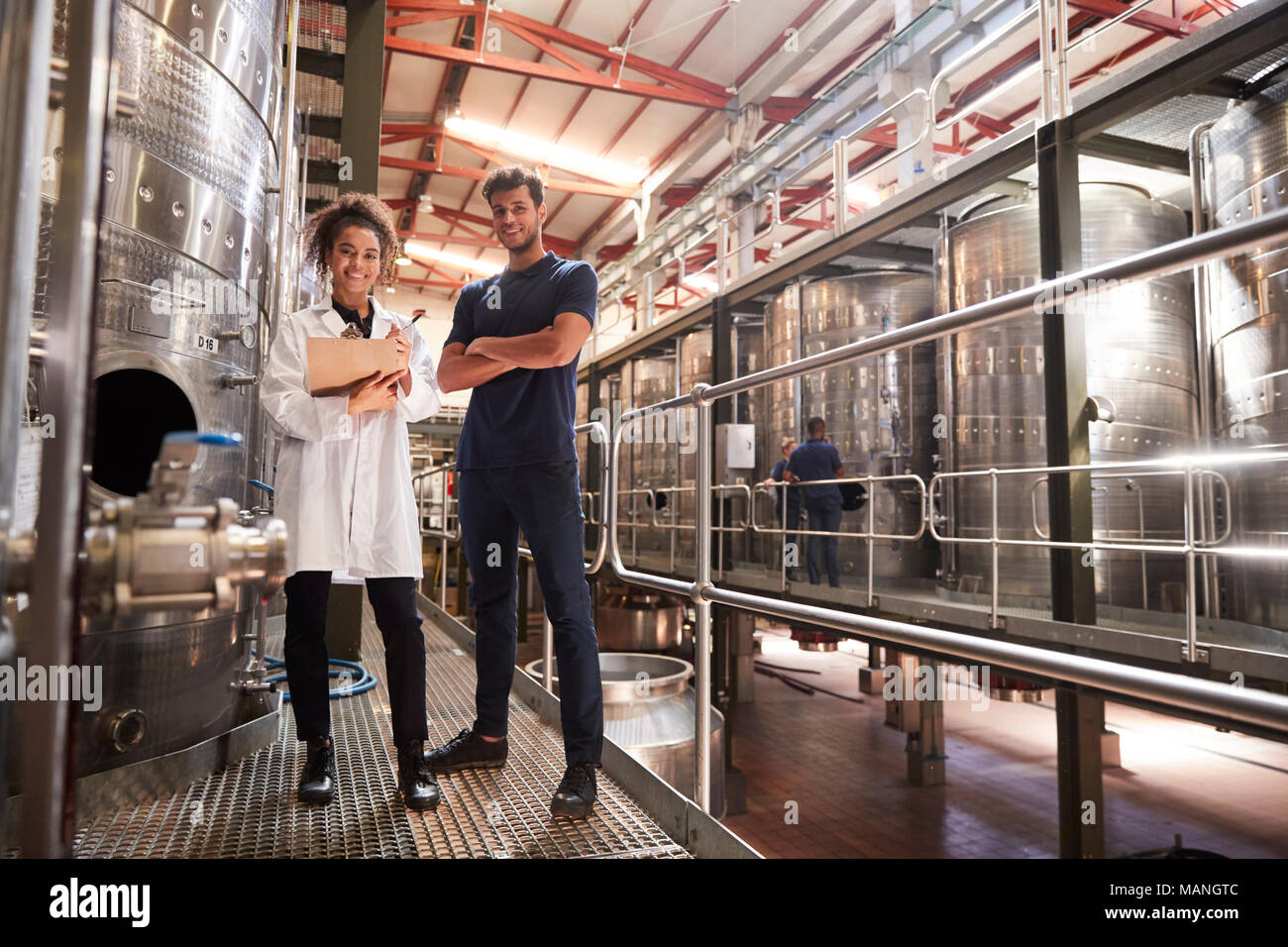 Männliche und weibliche Wein factory Techniker lächelnd in die Kamera Stockfoto