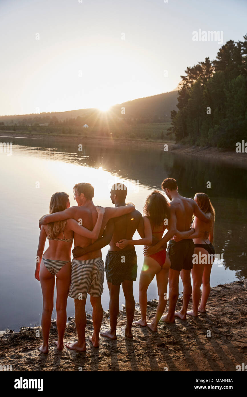 Junge Erwachsene Freunde stehen auf Lakeshore, vertikal Stockfoto