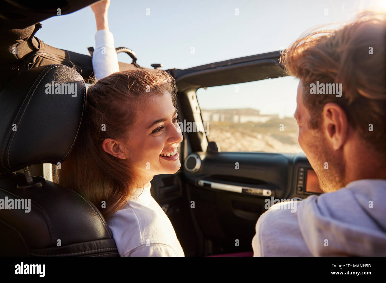 Paar schauen sich an während der Fahrt, auf der Beifahrerseite hinten POV Stockfoto