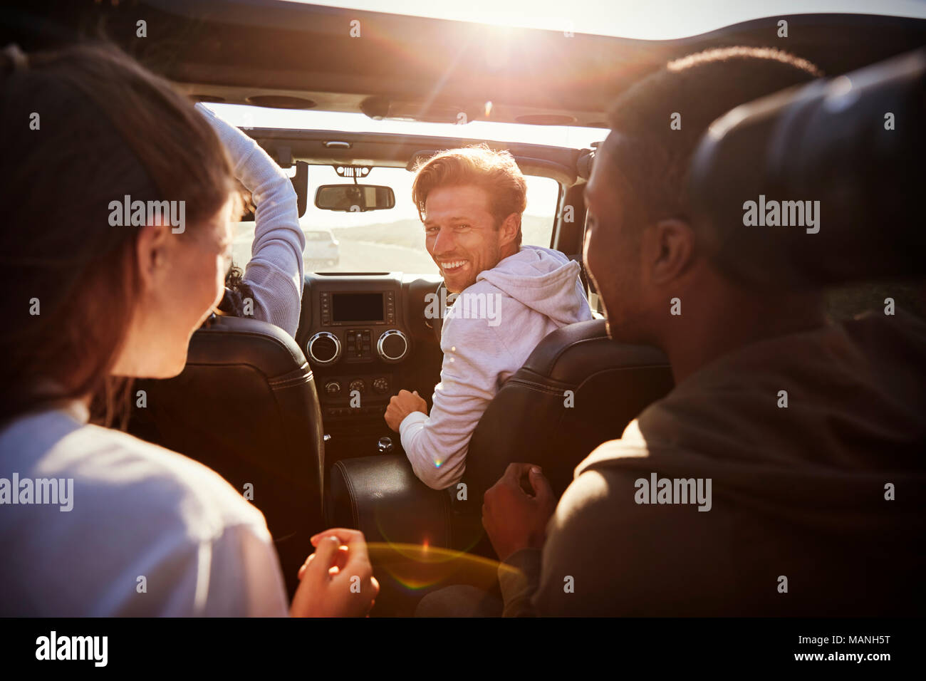 Vier junge erwachsene Freunde zusammen in ein Auto auf einer Straße Reise Stockfoto