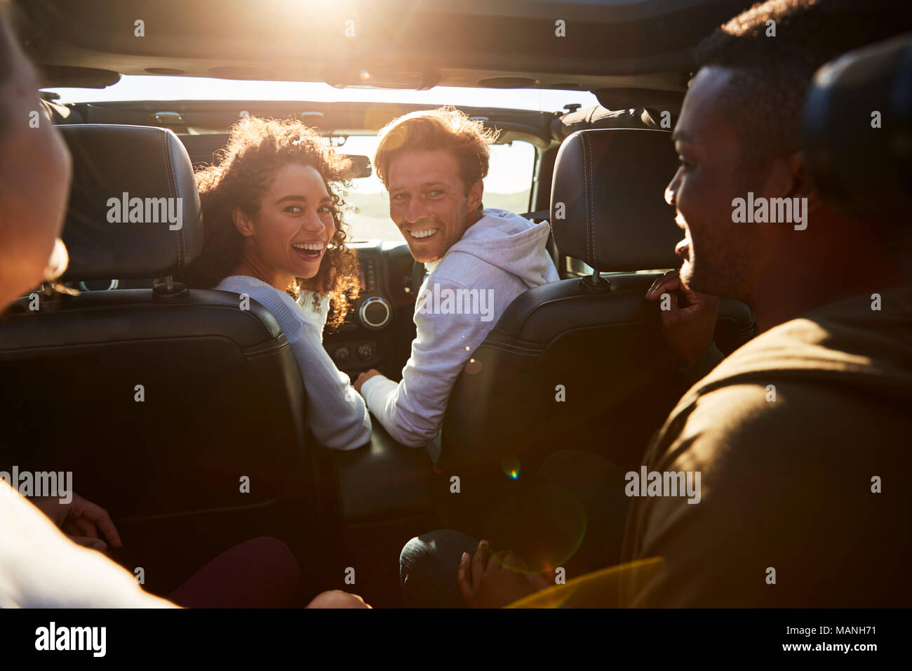 Vier junge erwachsene Freunde zusammen in einem Auto unterwegs Stockfoto