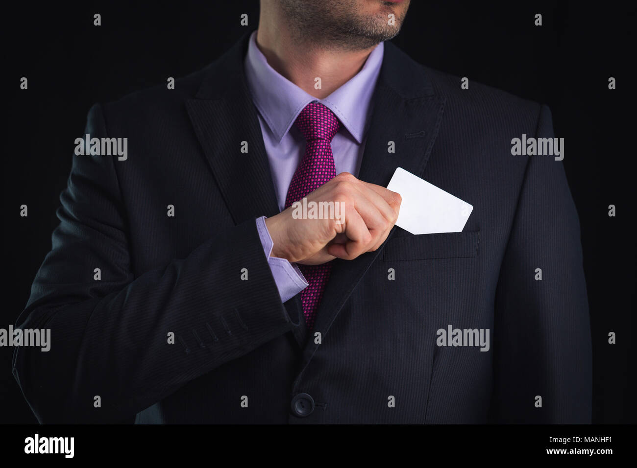 Unternehmer im eleganten Anzug und mit Krawatte, zeigt die Karte mit Kopie Raum, Studio shot Stockfoto