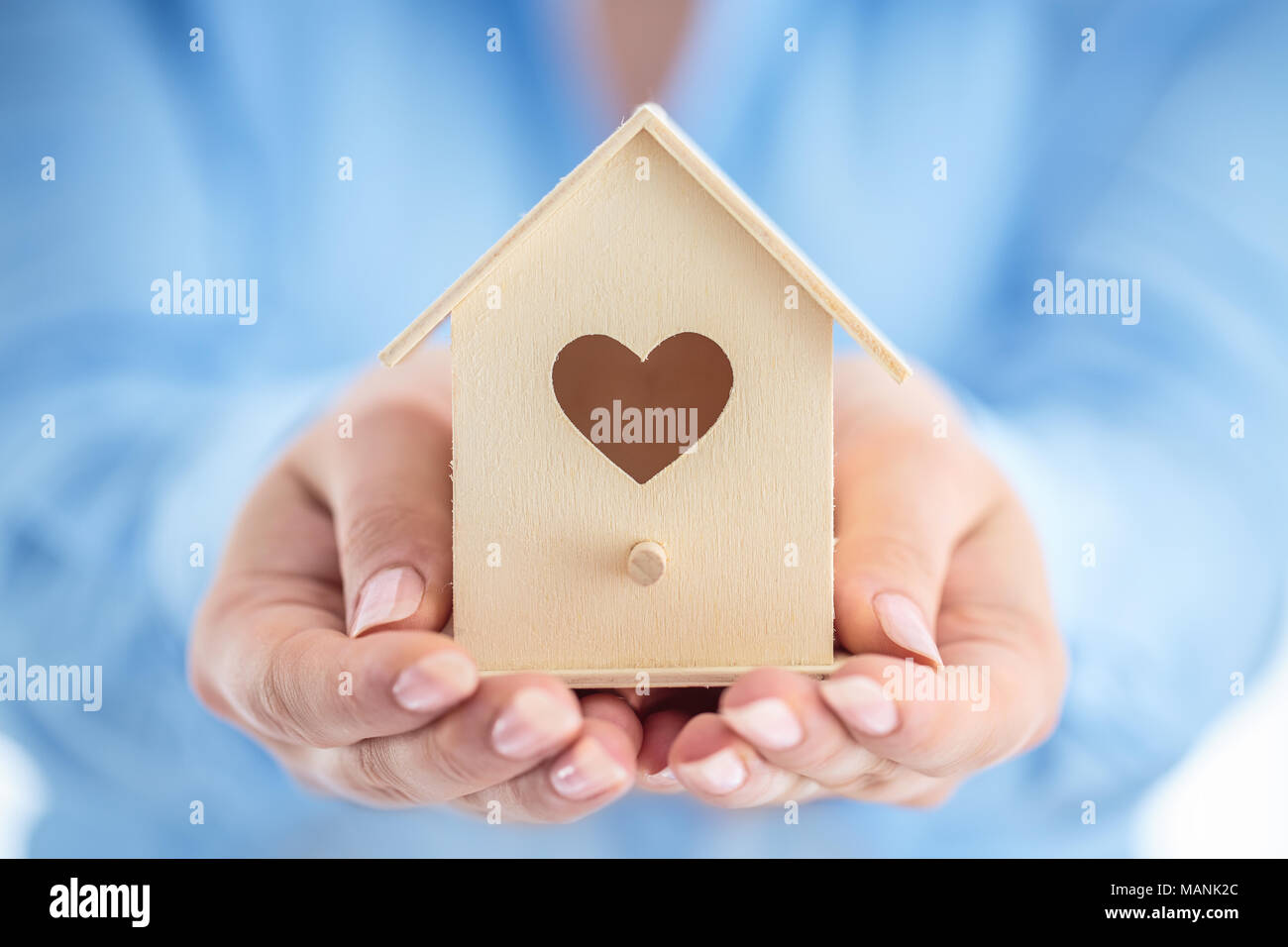 Kleines Holzhaus in Frau Hände schließen. Geschäftskonzept. Stockfoto