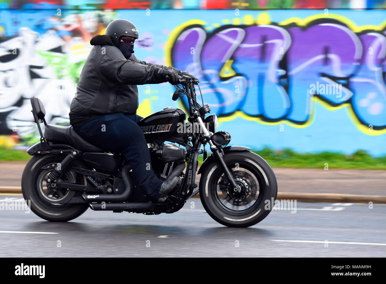 Fat adipösen Motorrad Fahrer reiten vorbei Graffiti an Southend Küste während der inoffiziellen Southend Shakedown Motorrad Rallye. Übergewicht Stockfoto