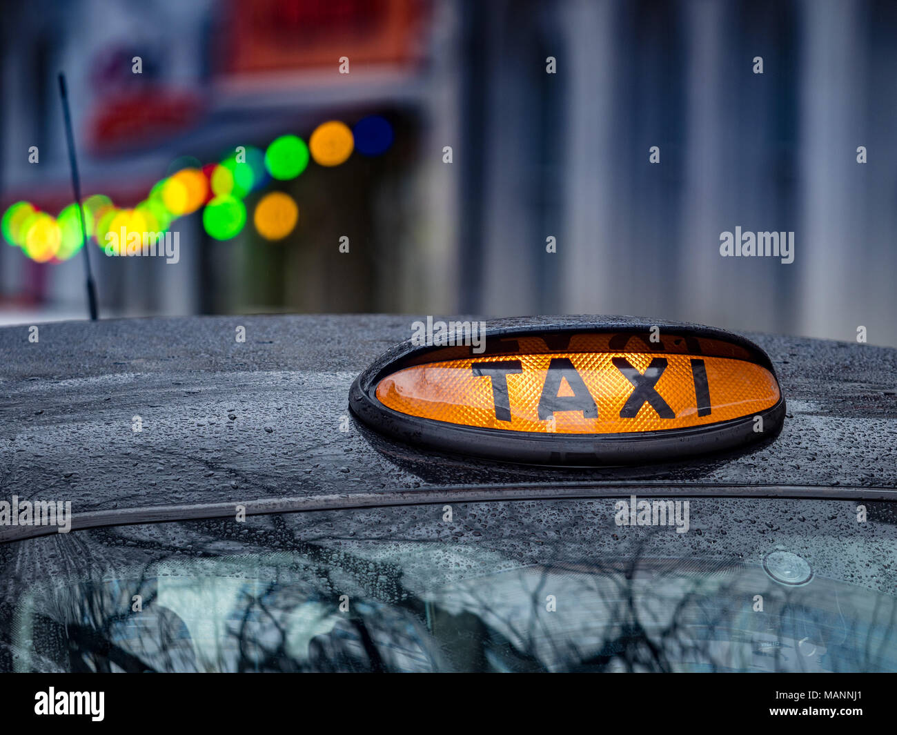 London Taxi Schild wartet auf Buchungen im Regen. London Taxi bei Regen. Schwarzes Londoner Fahrerhaus. Stockfoto