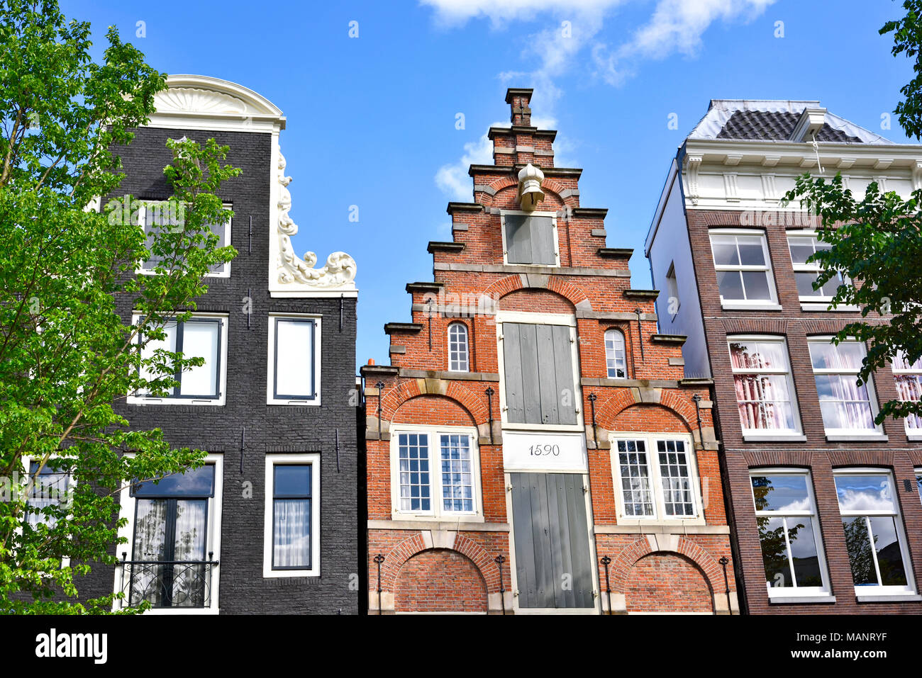 Stadt Häuser in Amsterdam, Niederlande. Außen oder Hausfassade mit blauen Himmel. Stockfoto