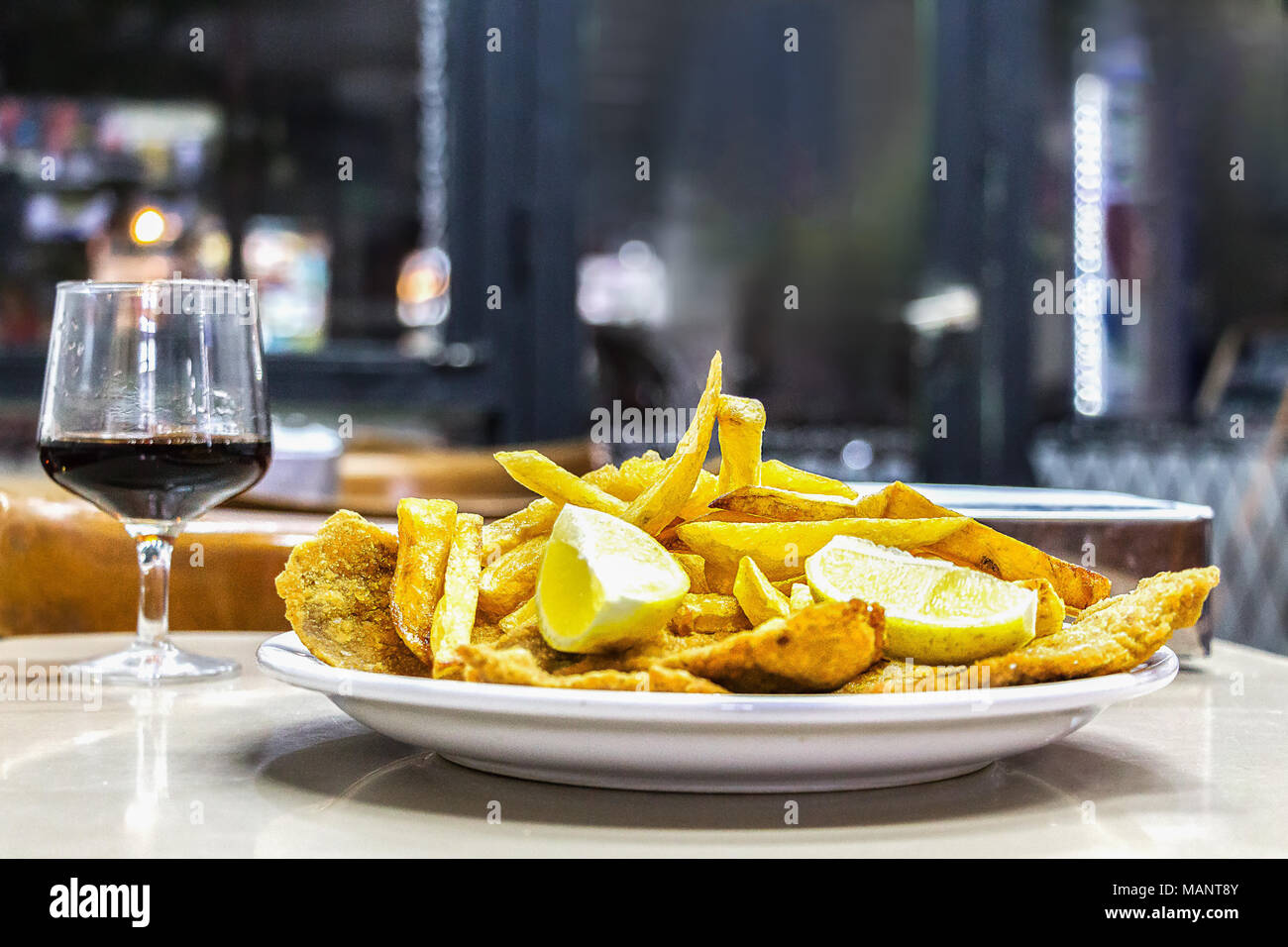 Eine Platte mit Milanesas con Papas fritas (Schnitzel mit Kuh Rind und Pommes frites Kartoffeln gemacht) auf einem hölzernen Tisch in einem kleinen Restaurant für Arbeitnehmer in Buenos Stockfoto