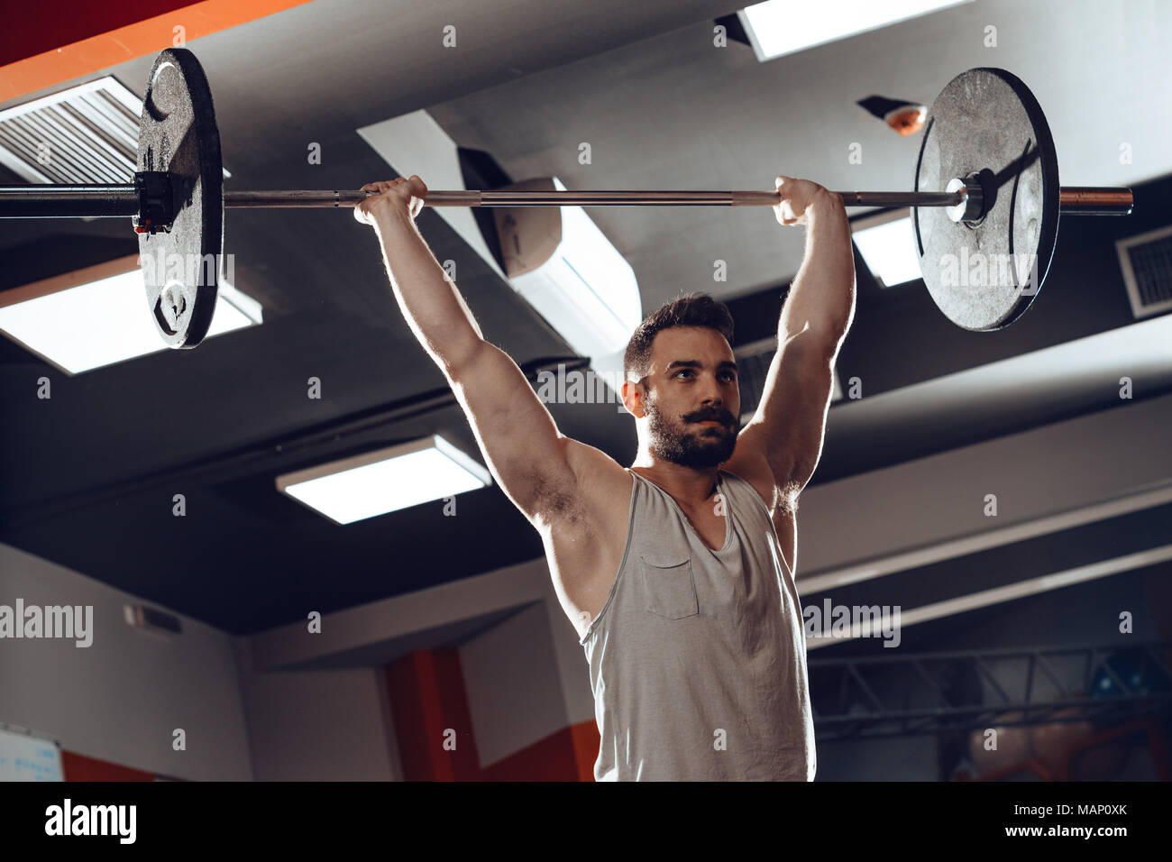 Junge muskulöse Mann Gewicht anheben einer Langhantel im Fitnessstudio. Stockfoto