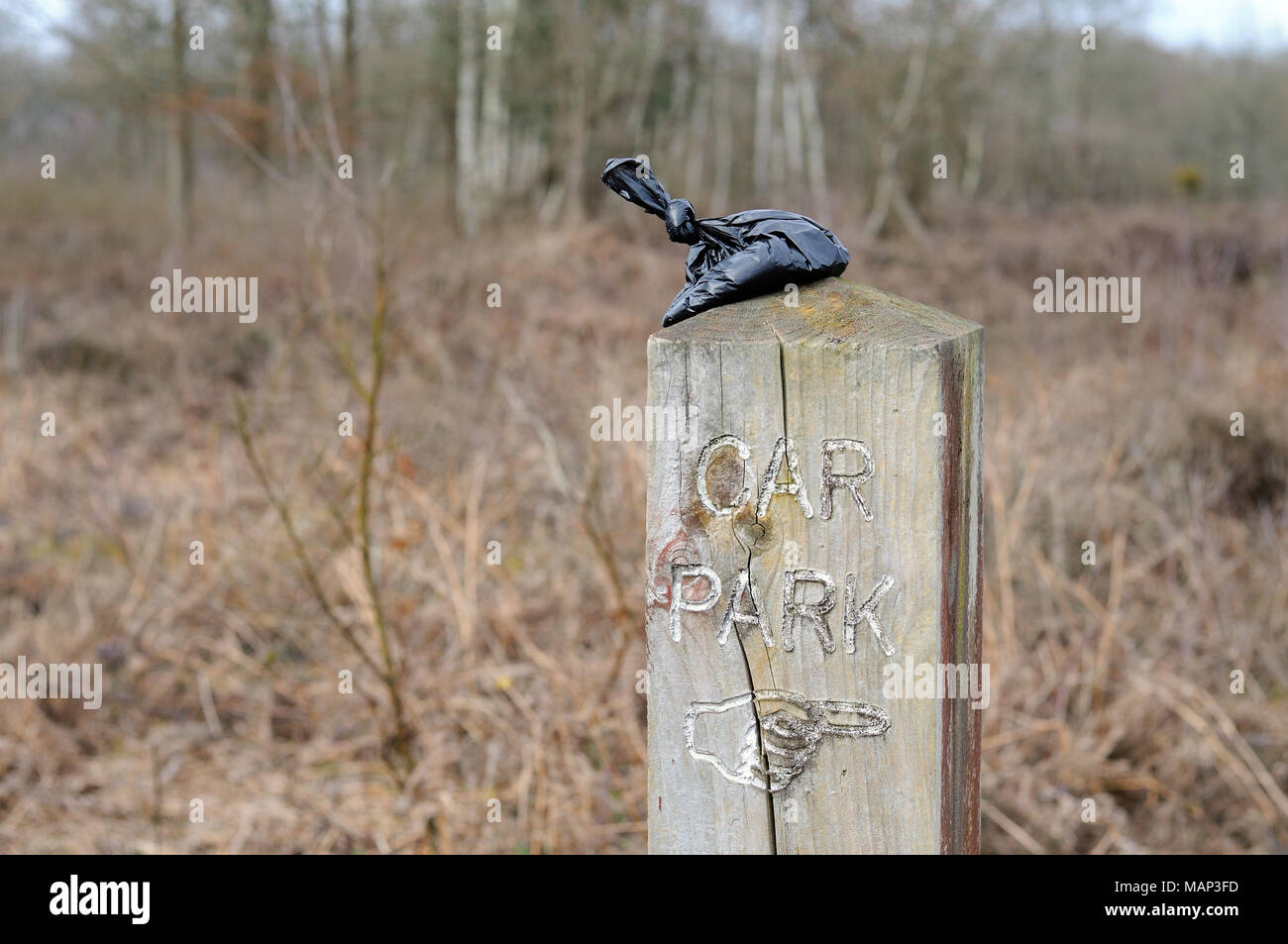 Hundehaufen Tasche links auf hölzernen Wegweiser Stockfoto