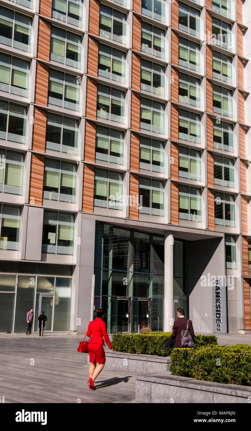 Frau in Rot auf dem Weg zum Bürogebäude, Southwark, London, England, Großbritannien Stockfoto