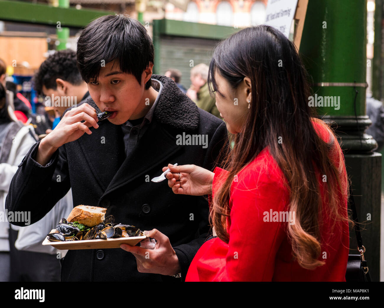 Paar essen Essen in der Nähe von Borough Market Street, Southwark, London, England, Großbritannien Stockfoto