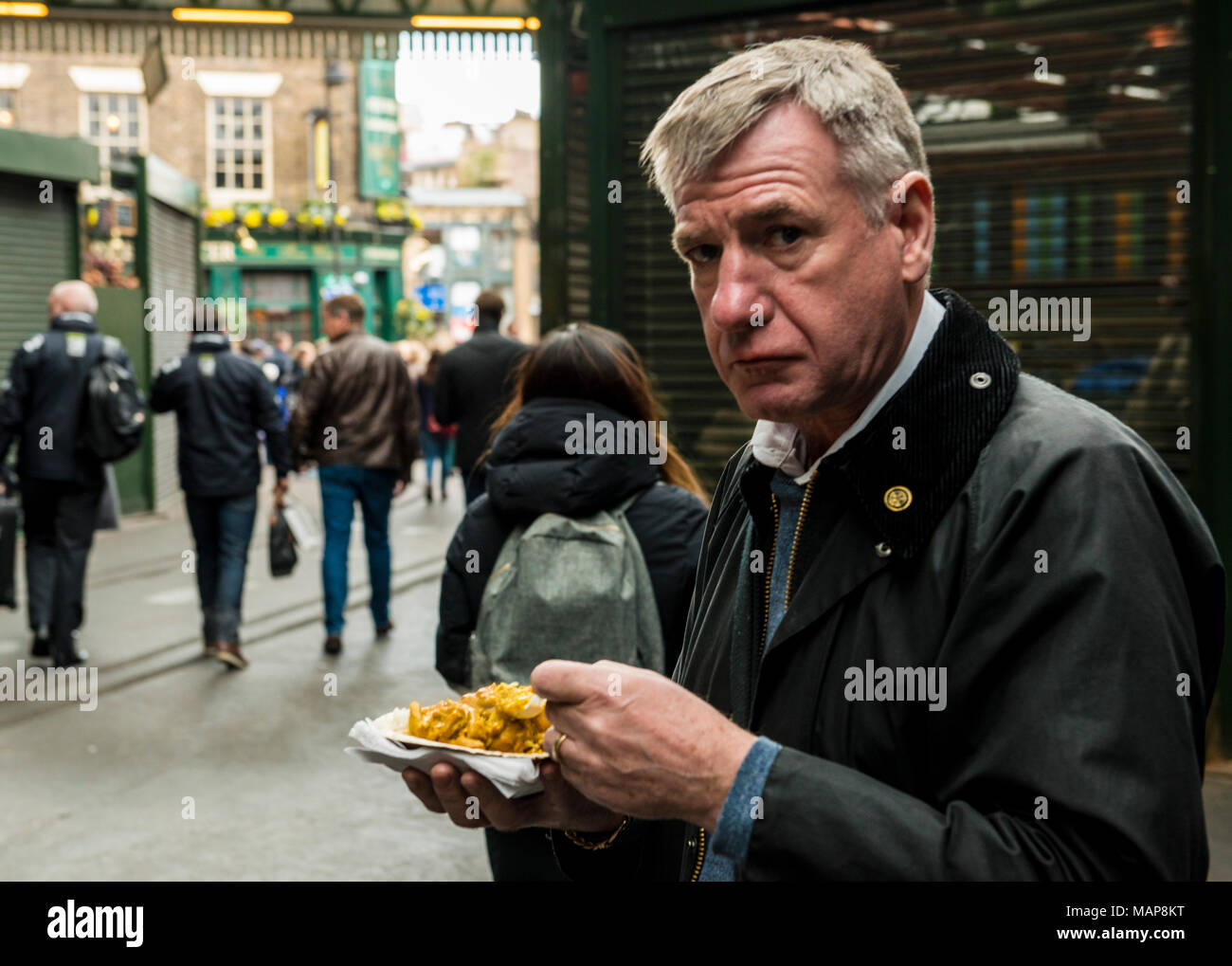 Mann essen Essen in der Nähe von Borough Market Street, Southwark, London, England, Großbritannien Stockfoto