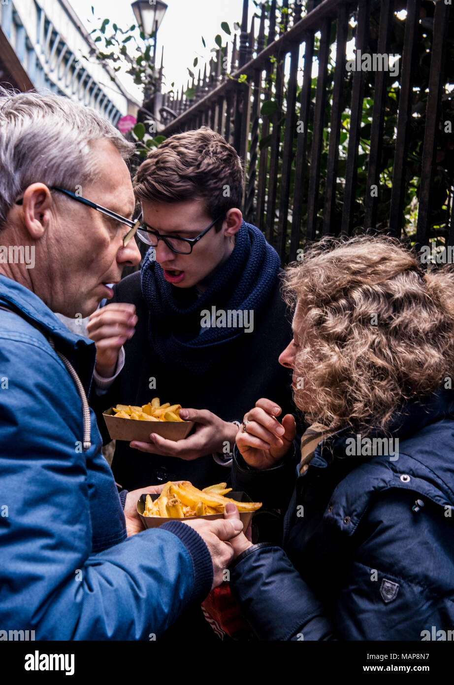 Drei Menschen essen Chips, London, England, Großbritannien Stockfoto