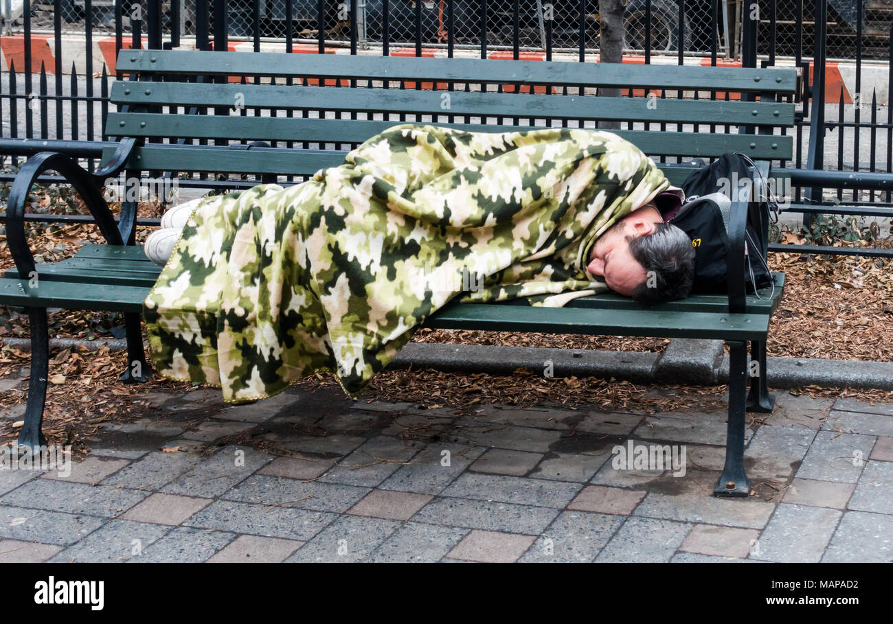Man schläft auf der Bank in einer kleinen New York City Park, in einem Dschungel, Tarnung Decke abgedeckt Stockfoto