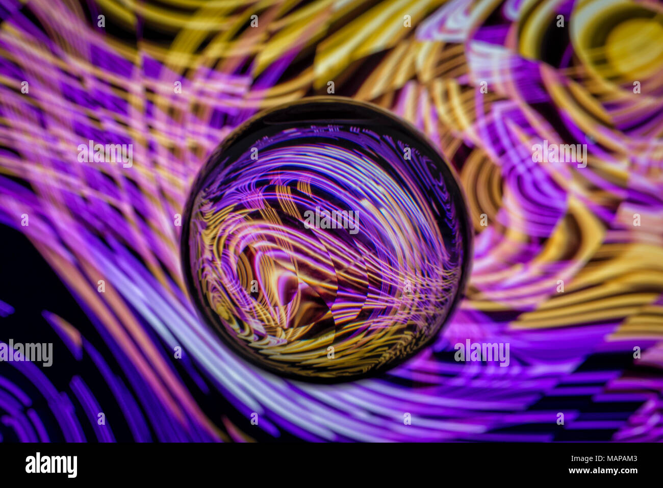 Klarglas Kugel mit farbigen Muster von Licht spiegeln sich darin. Stockfoto