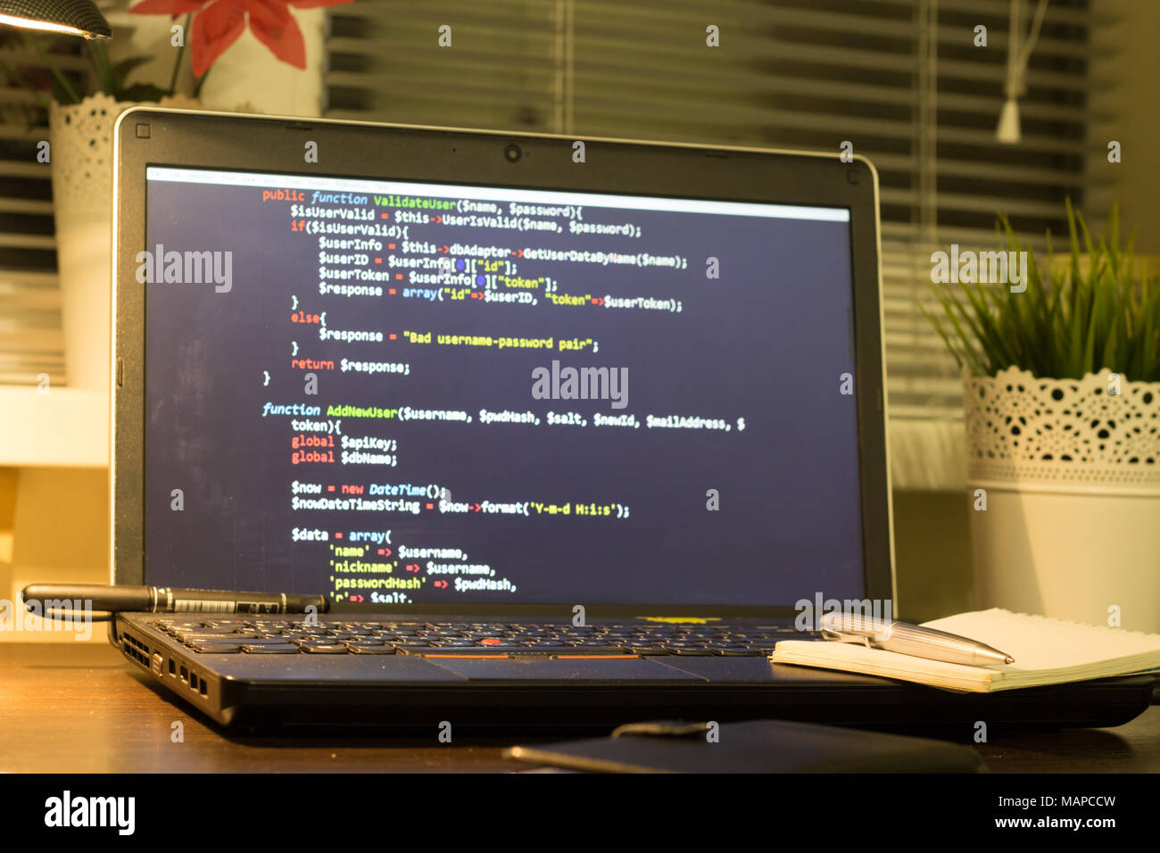 Die Web developer Arbeitsplatz. Laptop mit einem blocknote und ein Metall pen. Die digitale Technologie moderne Hintergrund. Stockfoto