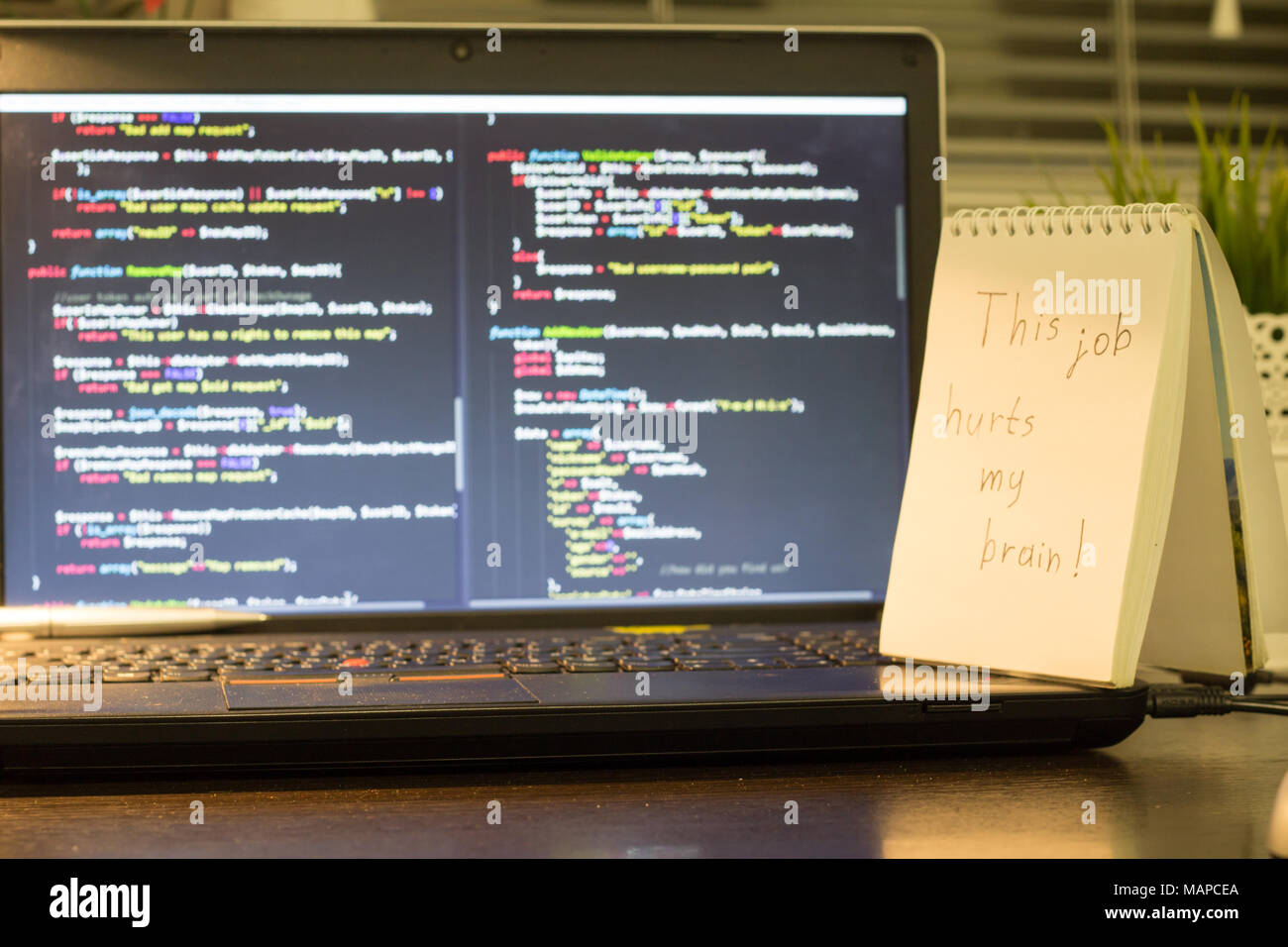 Die Web developer Arbeitsplatz. Laptop mit einem Hinweis zur Seite. Pause nach einem harten Arbeit Konzept. Die digitale Technologie moderne Hintergrund. Stockfoto
