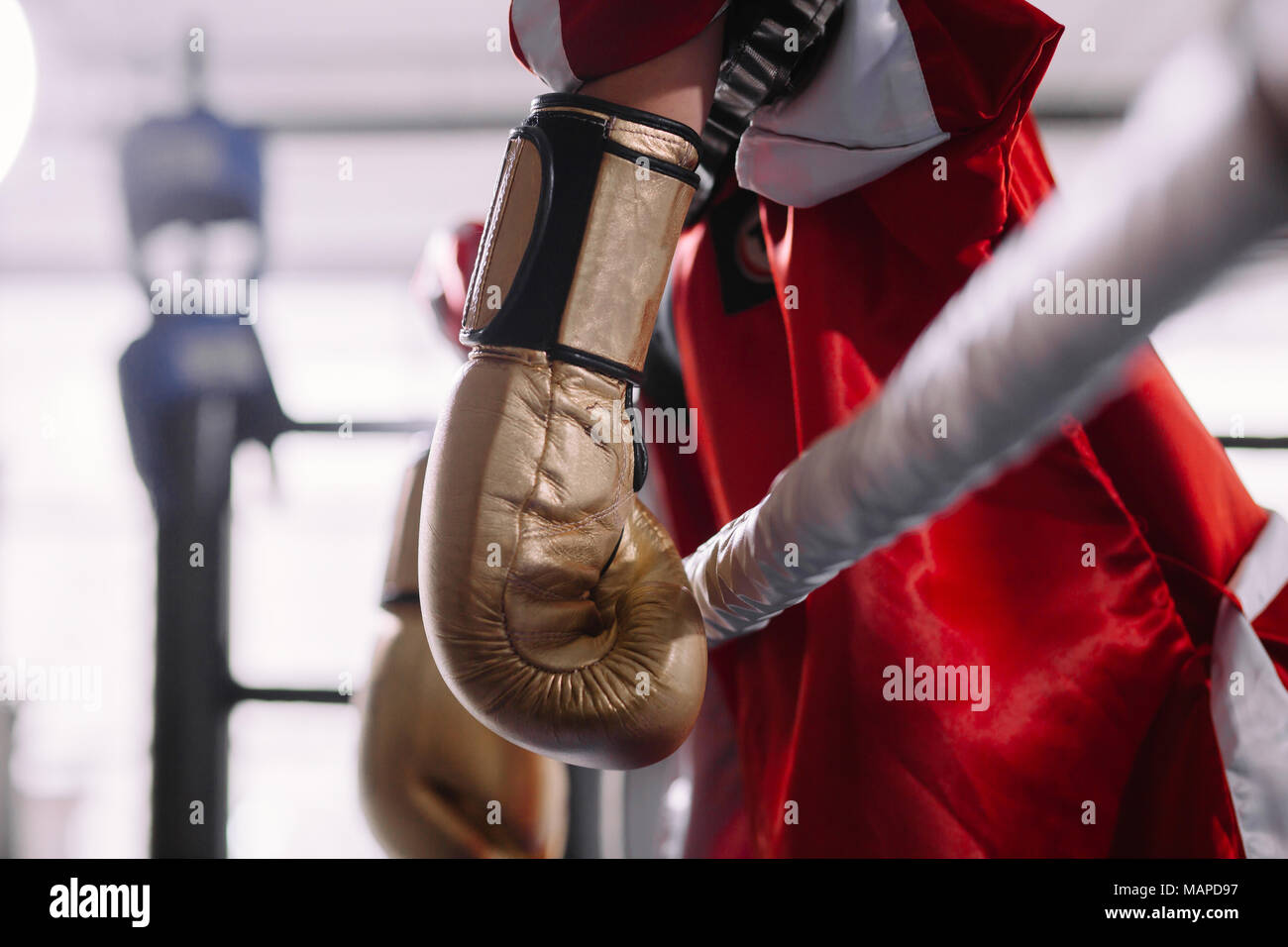 Geschlagenen Boxer in gelb Boxhandschuhe lehnte sich auf Seile Stockfoto