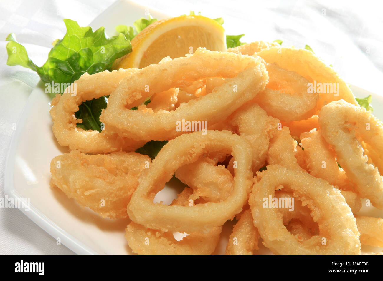 Frittierte Tintenfischringe Mit Grunem Salat Und Zitrone Stockfotografie Alamy