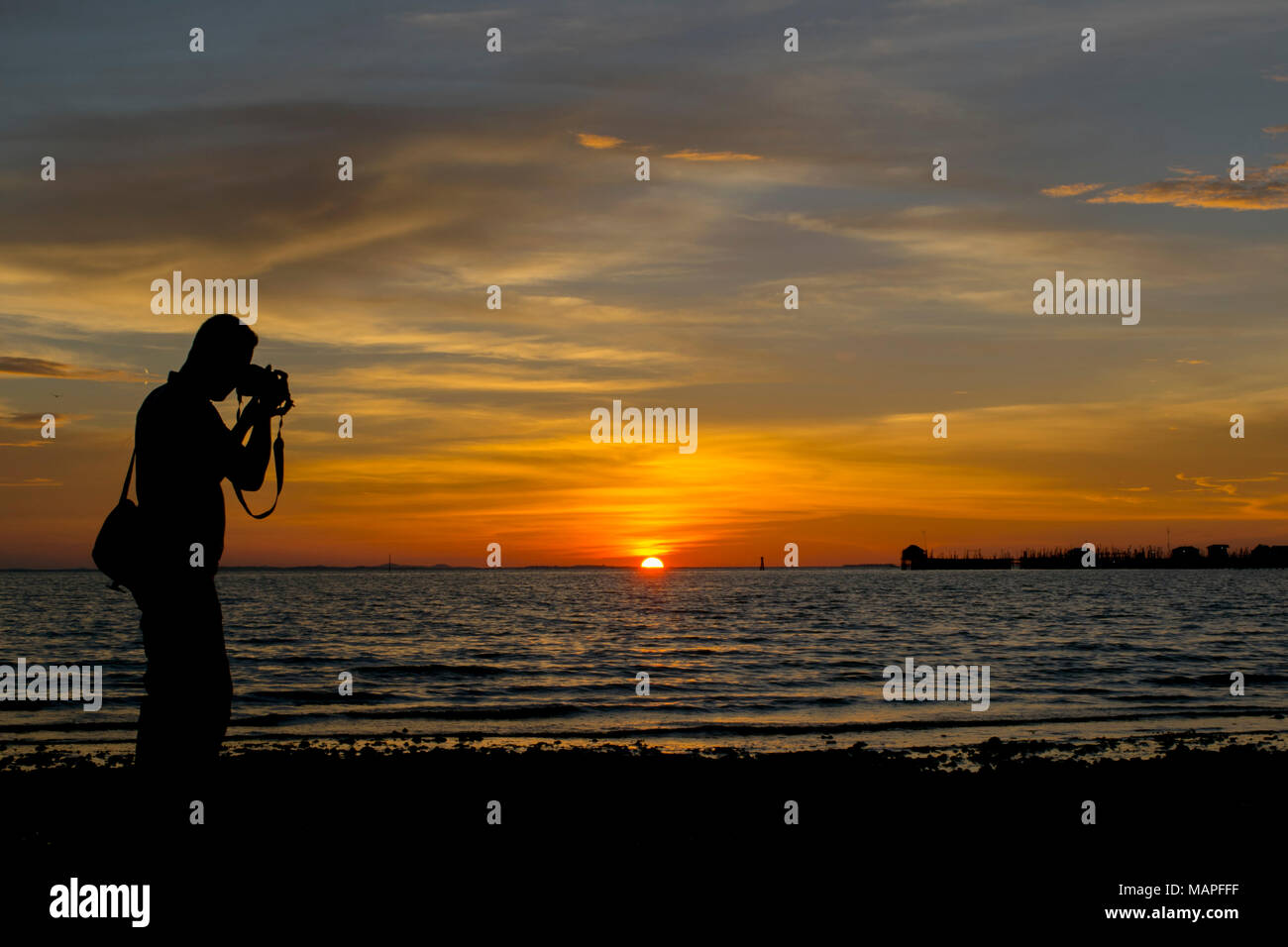 Silhouette Menschen fotografieren Meer gegen Sonnenuntergang - Bintan Island, Indonesien Stockfoto