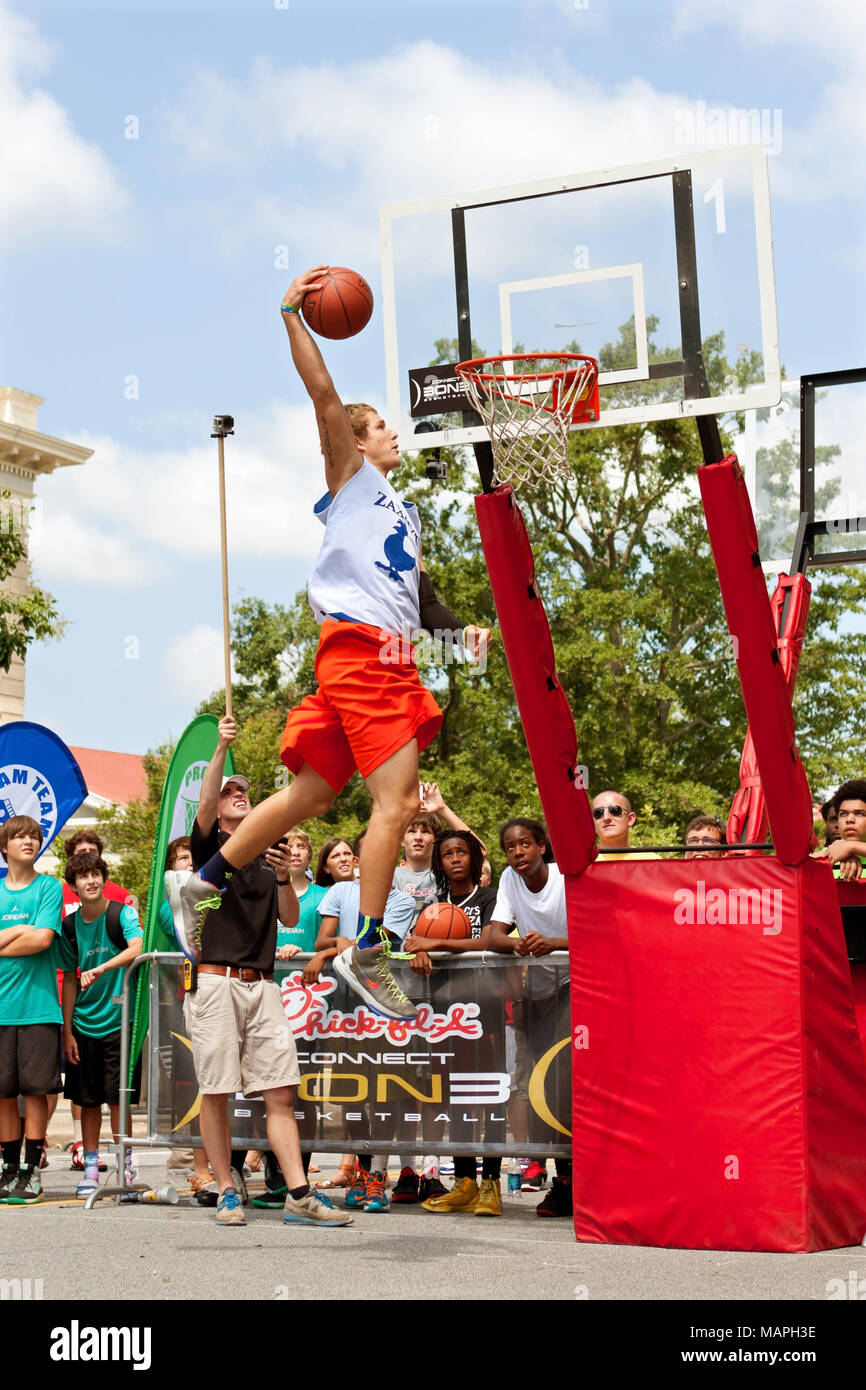 Ein junger Mann schwebt über der Felge ein Basketball in der Slam Dunk Wettbewerb eines 3-on-3 Basketball Turnier in Athen, GA am 24. August 2013 einzutauchen. Stockfoto