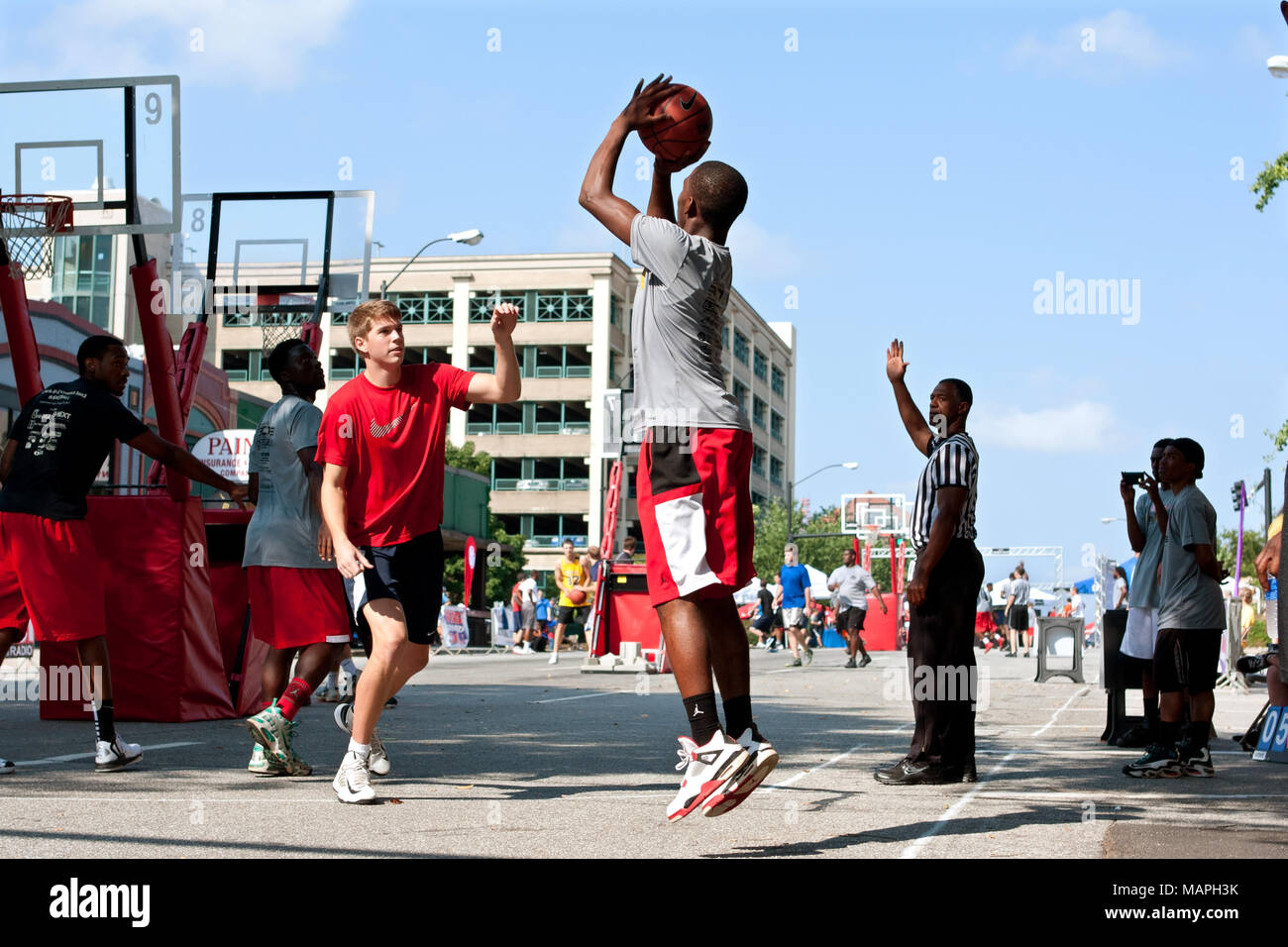 Ein junger Mann schießt ein Sprung in einem 3-on-3 Basketball Turnier statt auf den Straßen der Innenstadt von Athen, am 24. August 2013 in Athen, Ga erschossen. Stockfoto