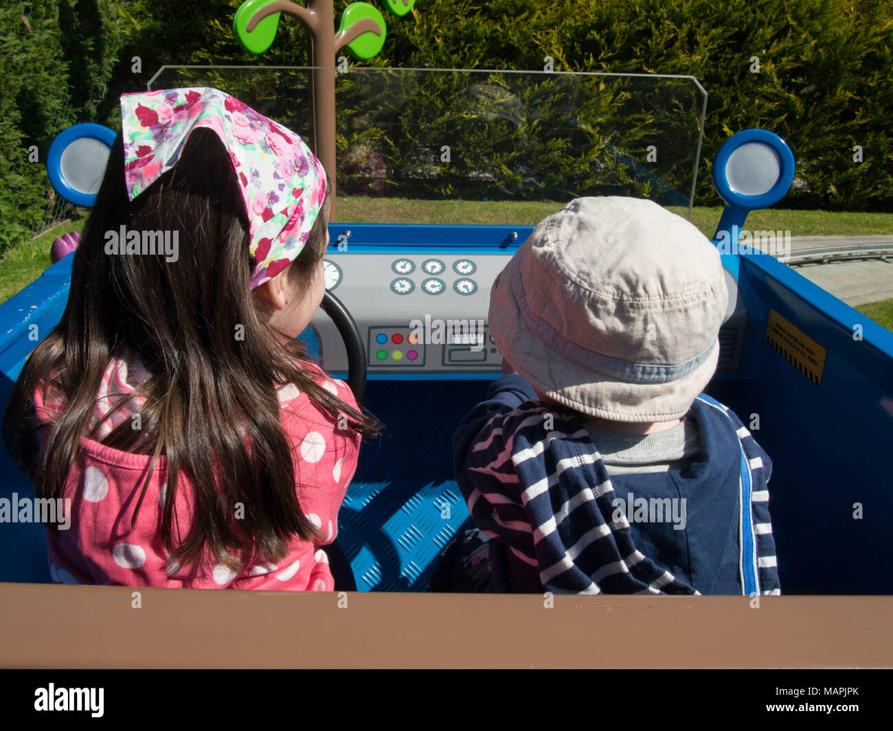 Zwei Kinder Fahrt auf Daddy Schweine auto Fahrt am Solitärspiele Welt, Paultons Park, Hampshire Stockfoto