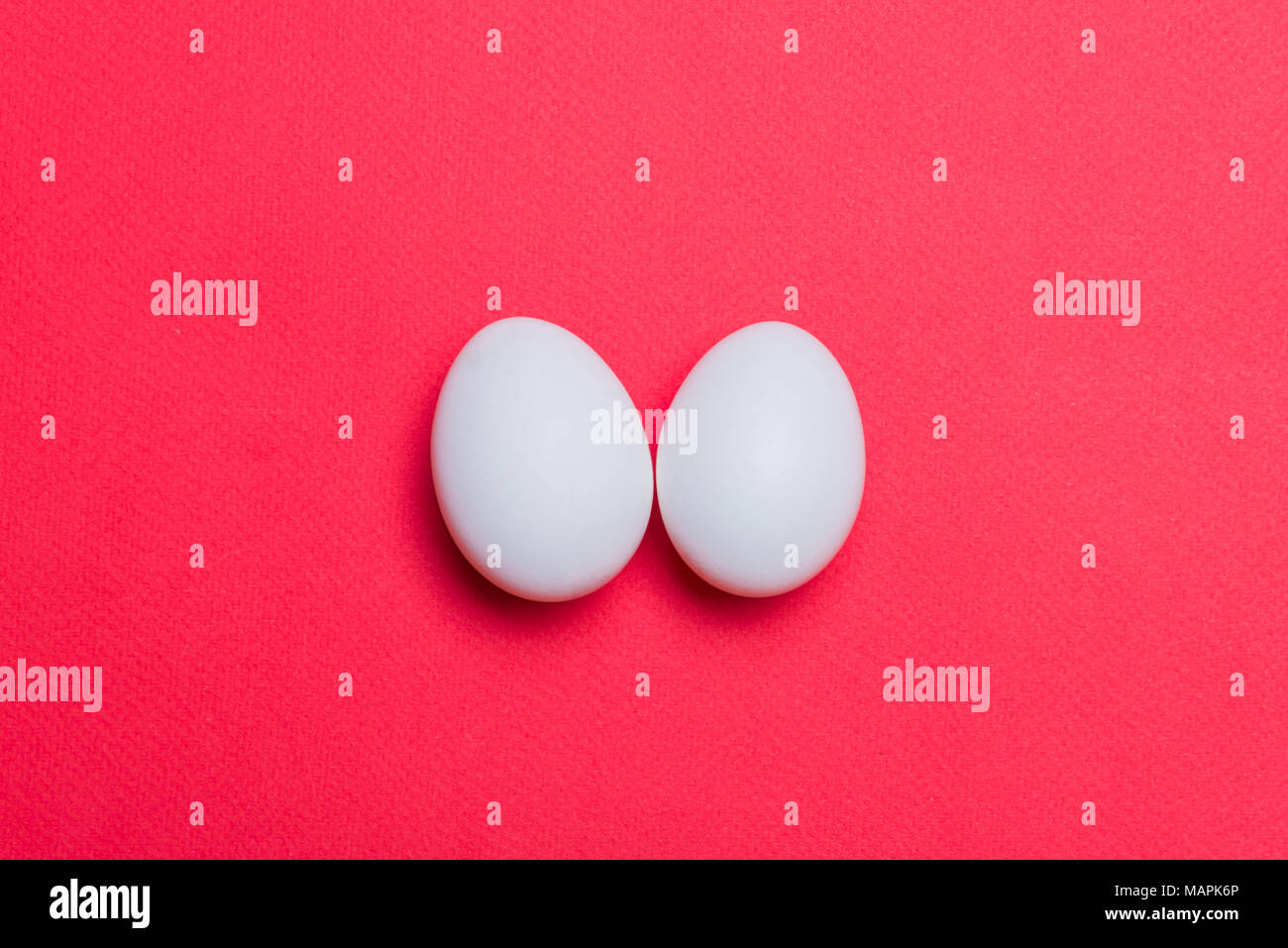 Zwei weiße Eier liegen auf dem Hintergrund Stockfoto