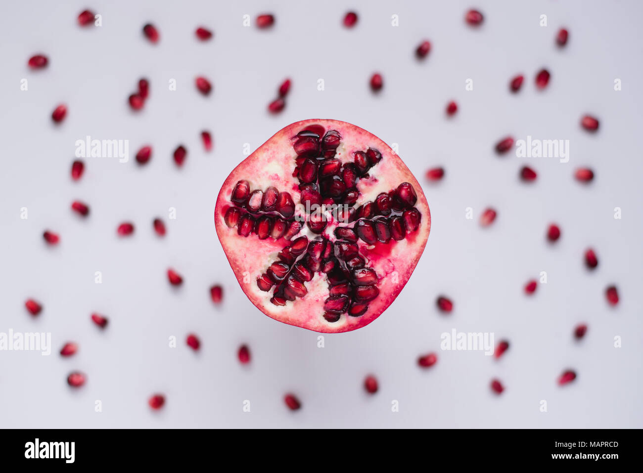 Das gesunde Essen rote Granatapfel auf unscharfen Hintergrund weiss mit Samen Stockfoto